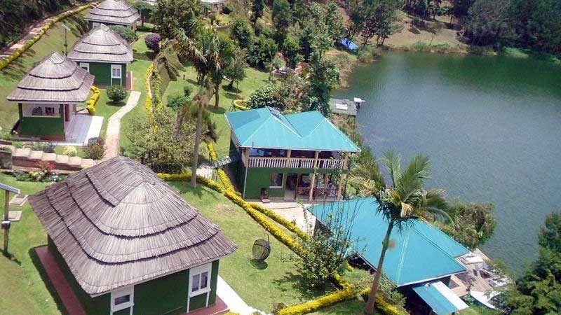 Aerial view of Bunyonyi Overland Resort showing thatched cottages and main lodge right on the shores of Lake Bunyonyi, Uganda.