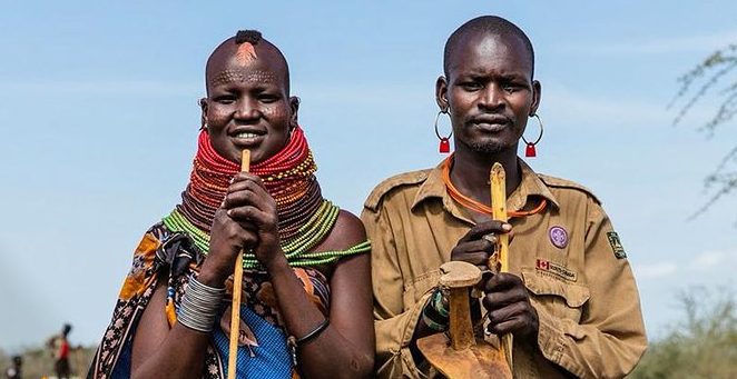 Portrait of a Karamojong man and woman wearing traditional beads and cultural attire from the northeastern region of Uganda.