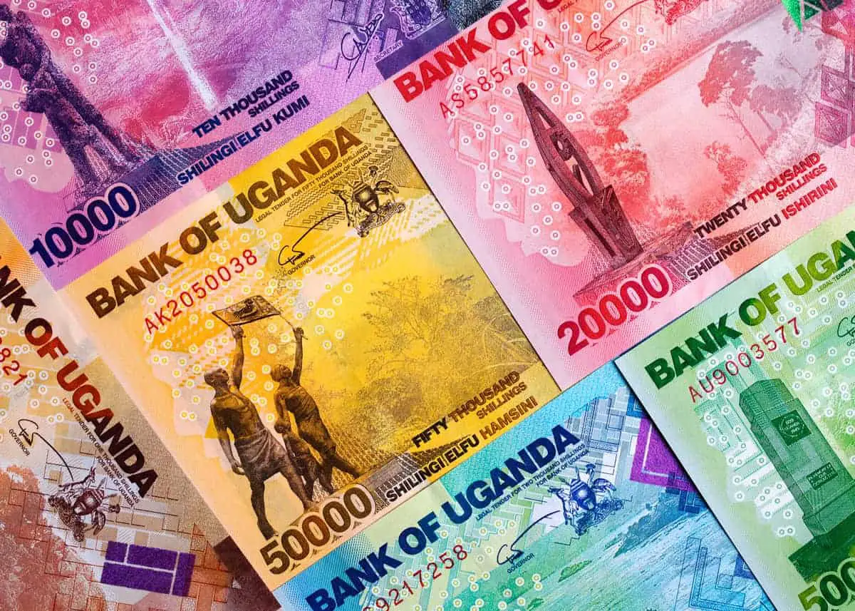 Close-up of colorful Ugandan currency bank notes (Shillings), showing the 10,000, 20,000, and 50,000 denominations, used for travel budgeting in Uganda.