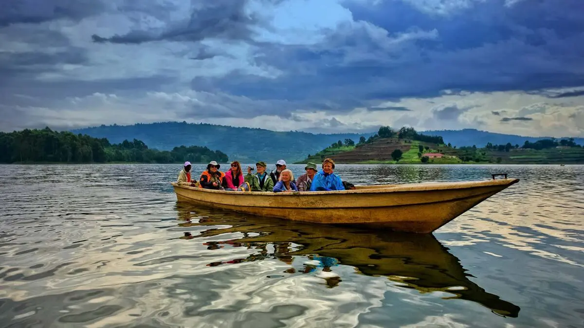 Dugout canoe on the deep, calm waters of Lake Bunyonyi, Uganda, surrounded by lush, terraced green hills