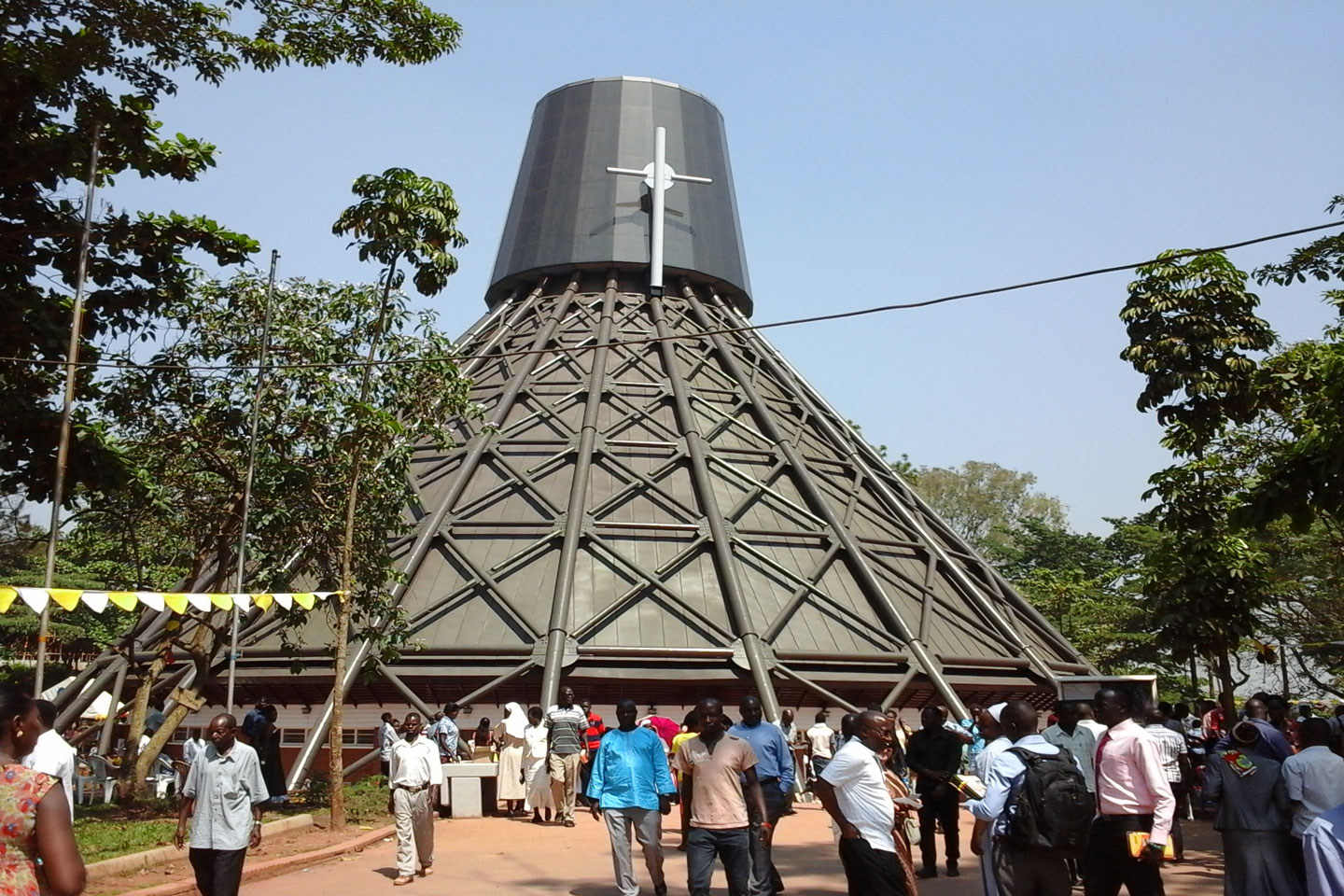 Uganda Martyrs Shrine Namugongo, architectural view of the conical church with pilgrims and a clear blue sky