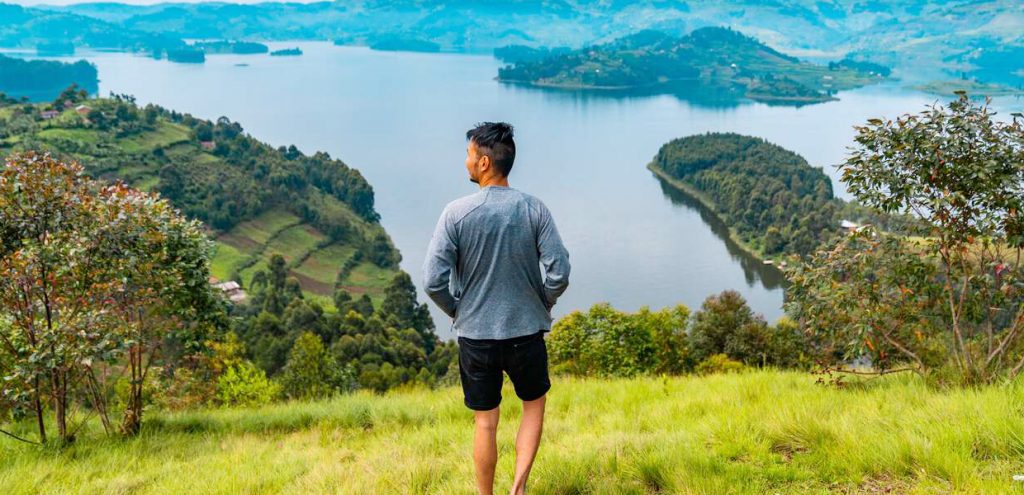 Man viewing Lake Bunyonyi, Uganda. Famous places in Uganda for sightseeing and terraced hills